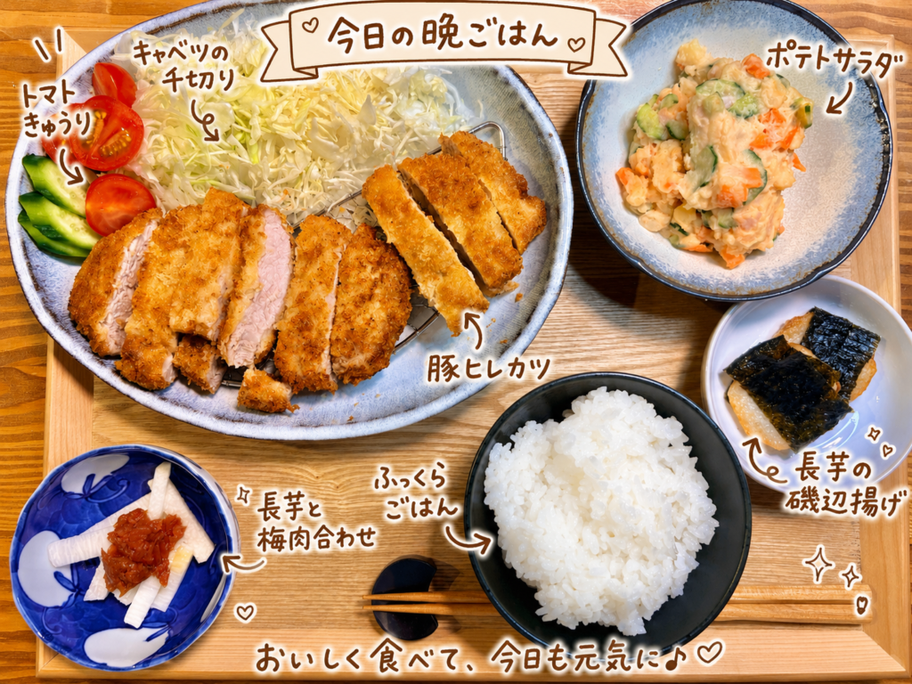 豚ヒレカツ、キャベツの千切り、トマト、きゅうり、ポテトサラダ、長芋の磯辺揚げ、長芋と梅肉合わせ、白ごはんを木製トレーに並べた晩ごはん献立。
