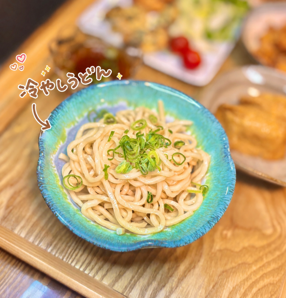 青い器に盛り付けた冷やしうどんの写真。つるっとした生うどんに刻みねぎをのせ、冷たいつゆでさっぱり楽しむ、暑い日の晩ごはんにぴったりな冷やしうどんの一品。