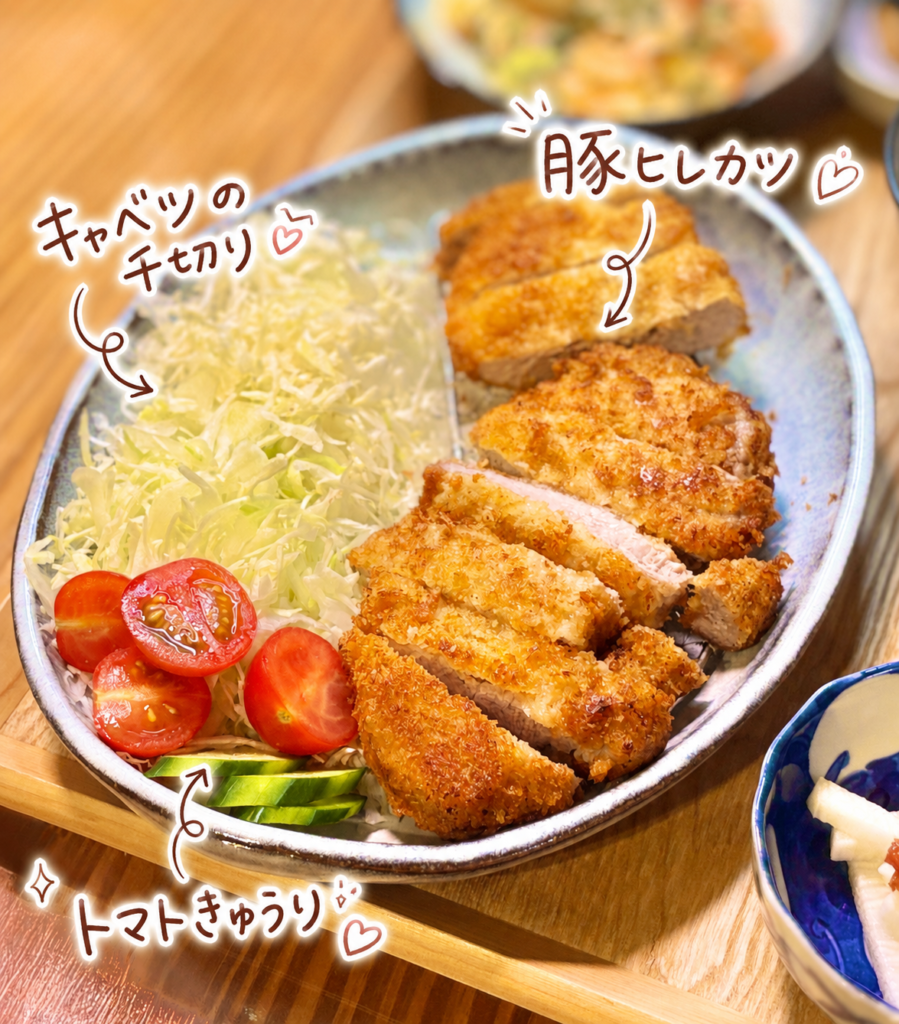 サクッと揚がった豚ヒレカツに、キャベツの千切り、トマト、きゅうりを添えたメインプレート。野菜も一緒に楽しめる満足感のある一皿。