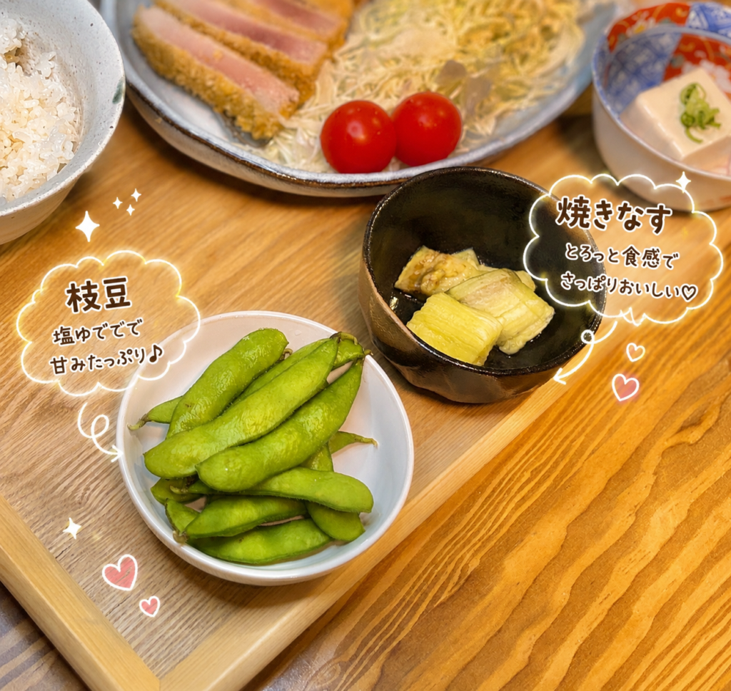 枝豆と焼きなすを小皿に盛りつけ、奥に魚フライと冷奴を添えた和風献立を手書き風の文字で紹介した写真