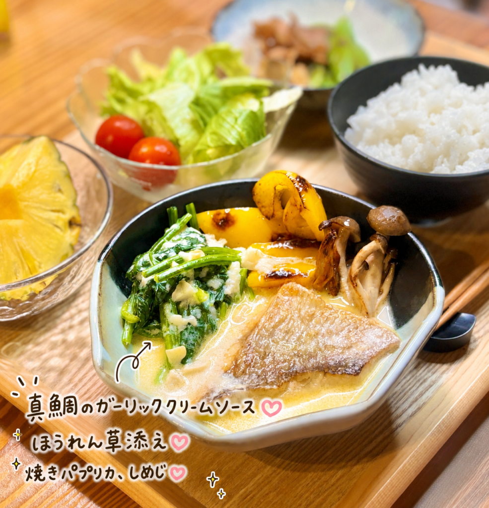 ふっくら焼いた真鯛のガーリッククリームソースに、ほうれん草と焼きパプリカ、しめじを添えた洋風魚料理の盛り付け