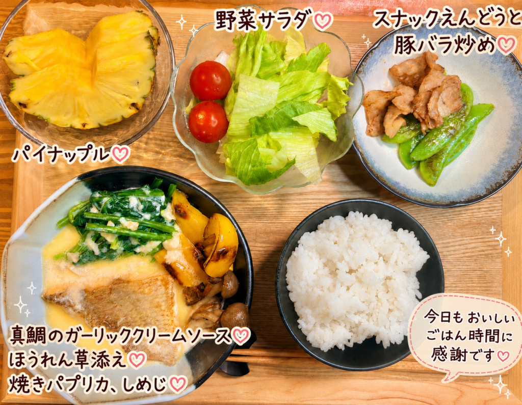 真鯛のガーリッククリームソースを主菜に、ほうれん草、焼きパプリカとしめじ、スナックえんどうと豚バラ炒め、野菜サラダ、パイナップルを合わせた晩ごはん献立