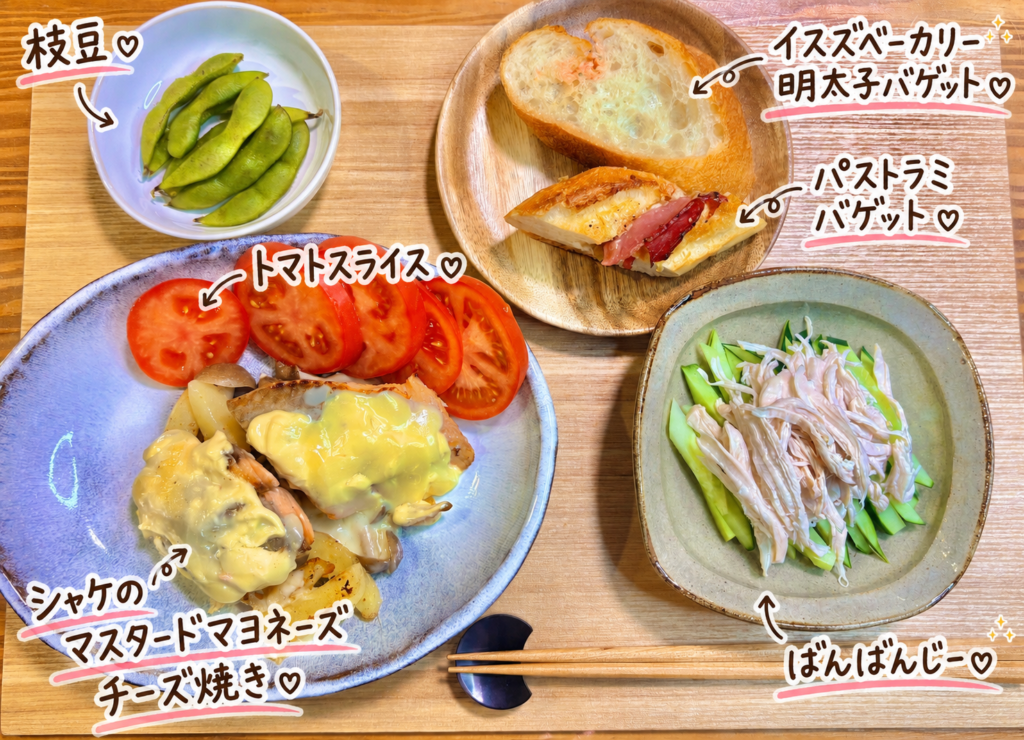 鮭のマスタードマヨネーズチーズ焼き、バンバンジー、トマトスライス、枝豆、イスズベーカリーの明太子バゲットとパストラミバゲットを並べた洋風晩ごはん献立