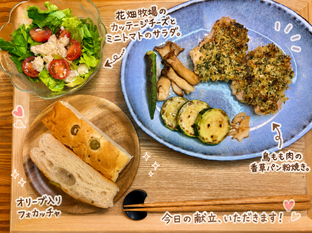 鶏もも肉の香草パン粉焼きをメインに、花畑牧場のカッテージチーズとミニトマトのサラダ、オリーブ入りフォカッチャ、焼きズッキーニ、しめじ、オクラを盛り付けた、おうちレストラン風ワンプレート献立。