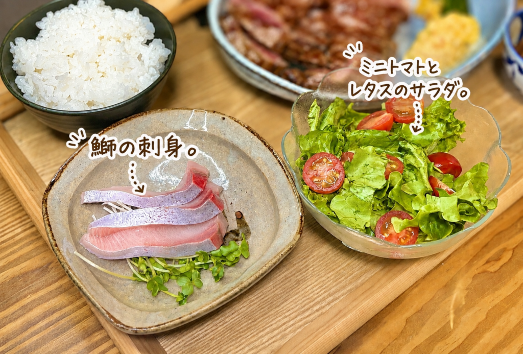 脂ののった鰤の刺身と、ミニトマトとレタスを使った彩り豊かな野菜サラダを並べた、オージービーフステーキに合う和洋折衷の副菜