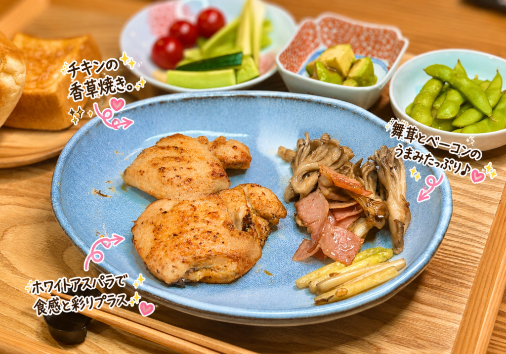 ジューシーなチキンの香草焼きと、ホワイトアスパラ・ベーコン・舞茸の旨み炒めを盛り付けたワンプレート料理。香ばしい焼き色が食欲をそそる簡単おうちごはんレシピ。