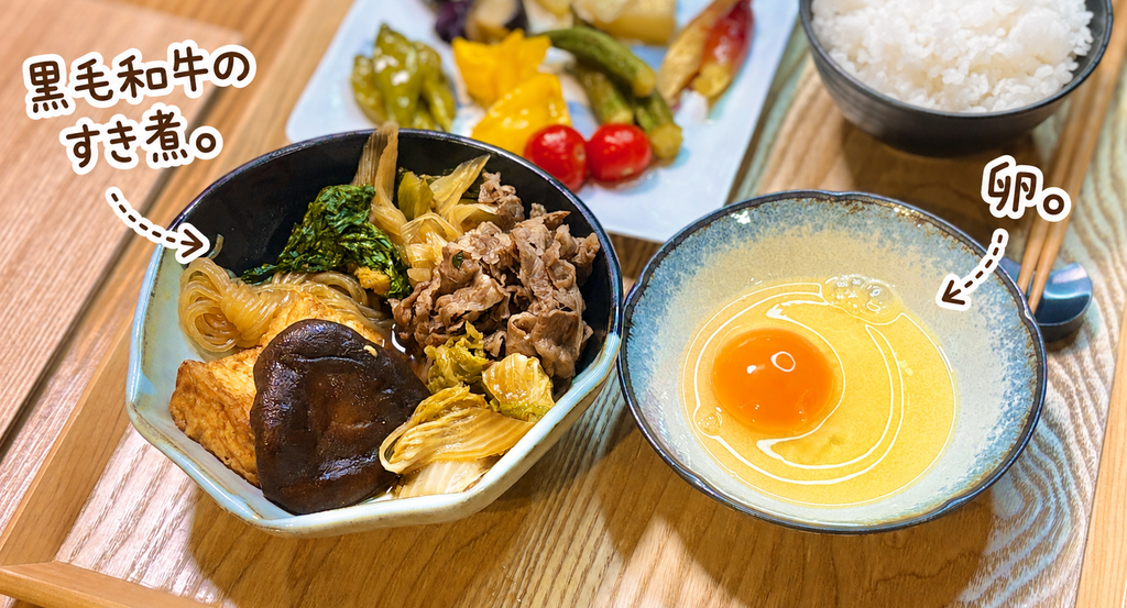 黒毛和牛のすき煮に白菜、椎茸、厚揚げ、春菊、糸こんにゃく、白ねぎをたっぷり入れ、生卵を添えた白ごはんが進む具だくさん牛肉料理