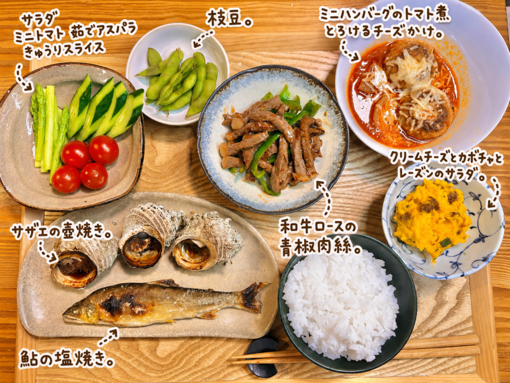 鮎の塩焼きとサザエの壺焼き、和牛ロースの青椒肉絲、ミニハンバーグのトマト煮チーズかけ、クリームチーズとかぼちゃとレーズンのサラダ、枝豆と野菜サラダを並べた豪華晩ごはん献立