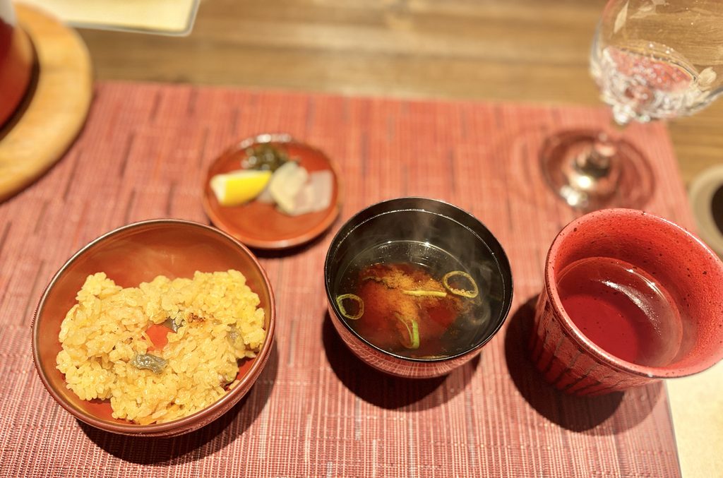 あわじ浜離宮 別荘 鐸海の夕食コースの御飯物。麦わら蛸と夏野菜のパエリアを茶碗によそい、汁物と御飯のお供を添えた一膳