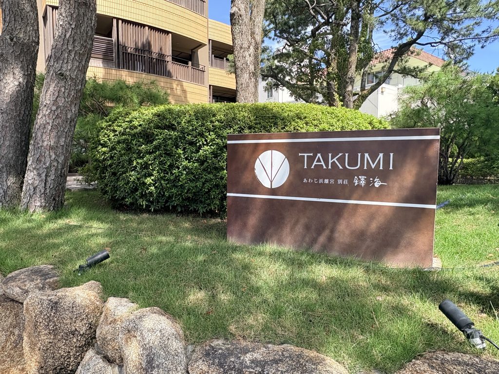 淡路島の宿「あわじ浜離宮 別荘 鐸海(TAKUMI)」の入口看板。緑と松に囲まれた落ち着いたリゾート旅館