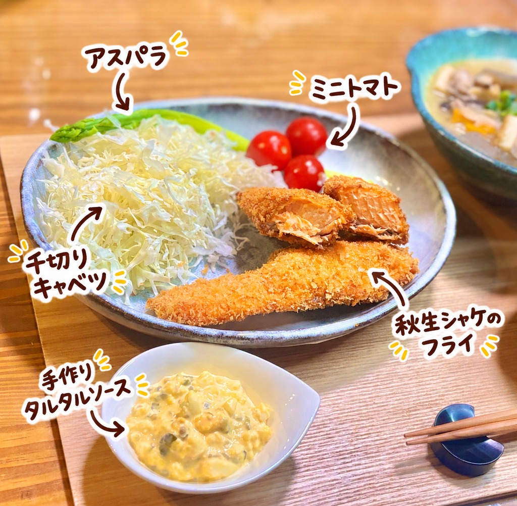 サクサクに揚げた秋生シャケのフライと、千切りキャベツ、アスパラ、ミニトマト、自家製タルタルソースを盛り付けた一皿