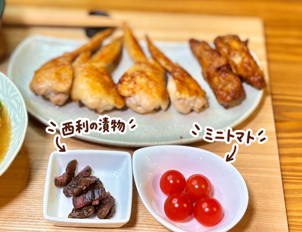 京都・西利の漬物と鮮やかなミニトマトを小皿に盛り付けた、牛肉の八宝菜と手羽先献立の箸休め