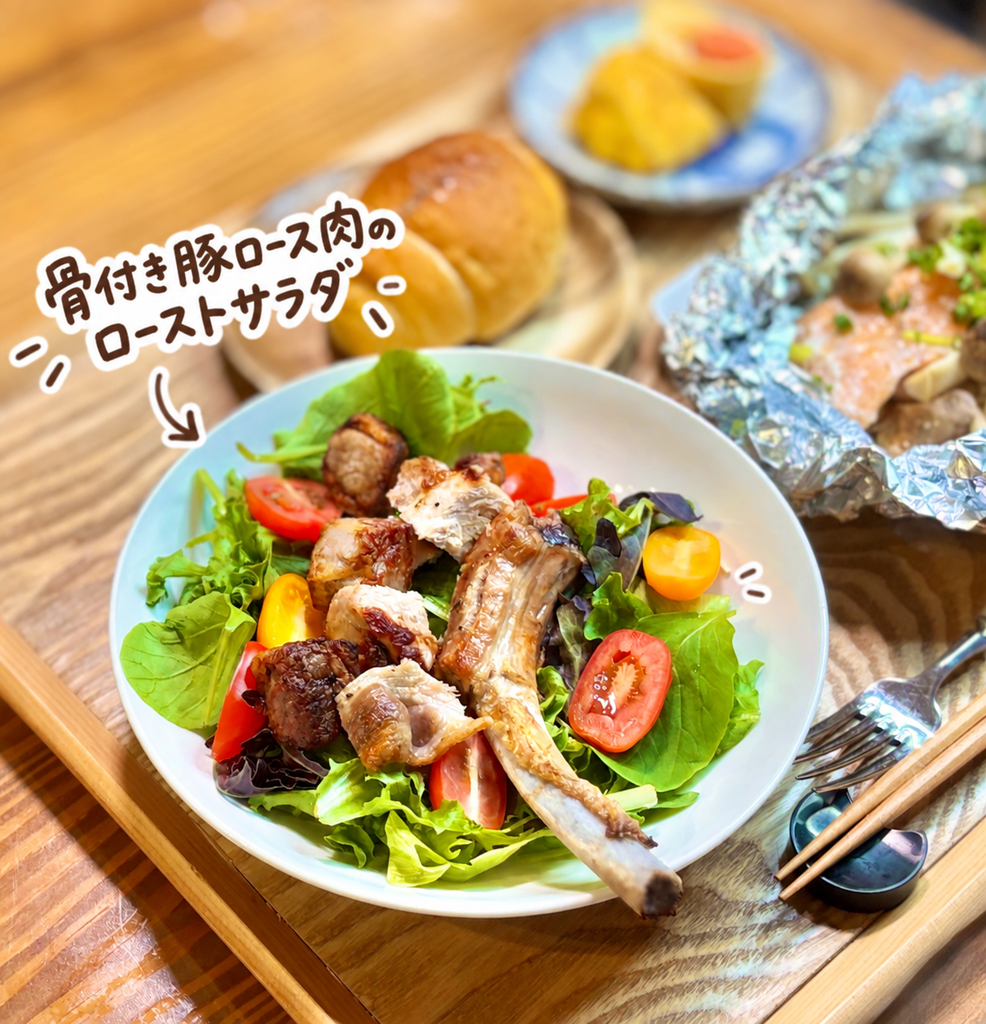 香ばしく焼いた骨付き豚ロース肉を葉野菜とカラフルなトマトに盛り付けたボリューム満点のローストサラダ