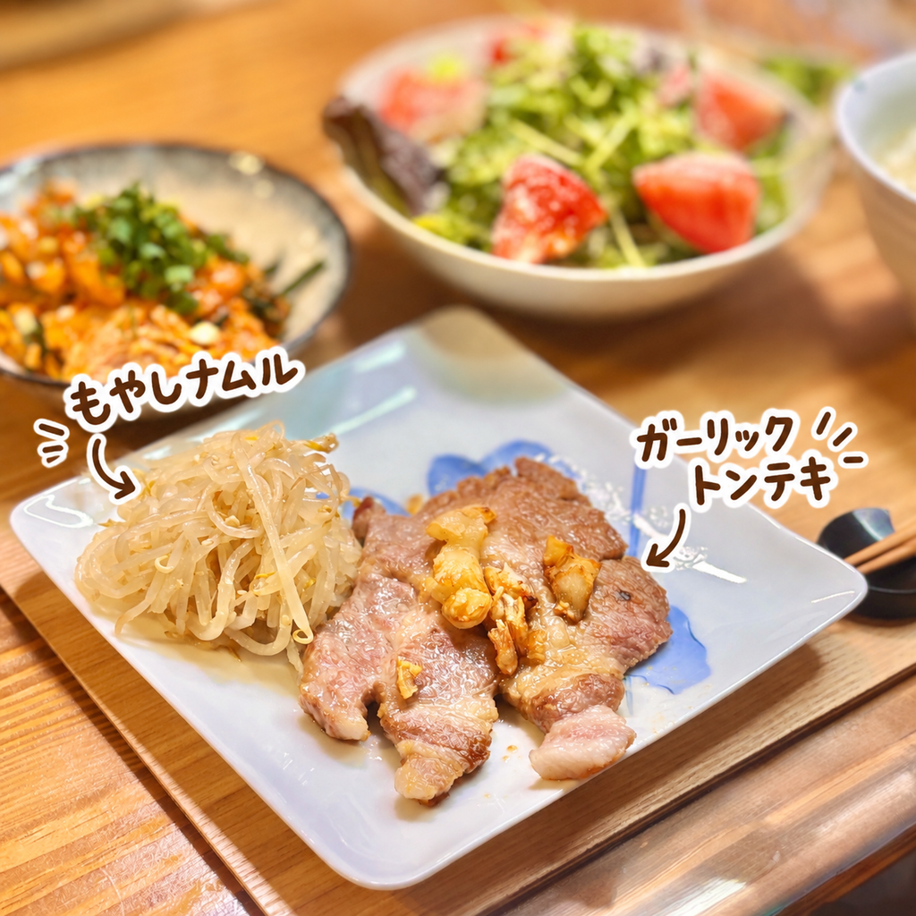 にんにくをのせたガーリックトンテキともやしナムルの盛り付け。豚肉を使ったご飯が進む簡単おかず