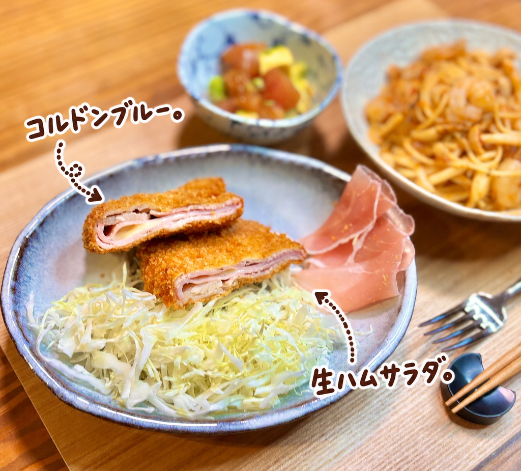 サクサクの衣にハムとチーズを挟んだコルドンブルーと、千切りキャベツに生ハムを添えたサラダ。ハムとチーズの断面が見える食べ応えのある洋食メインおかず