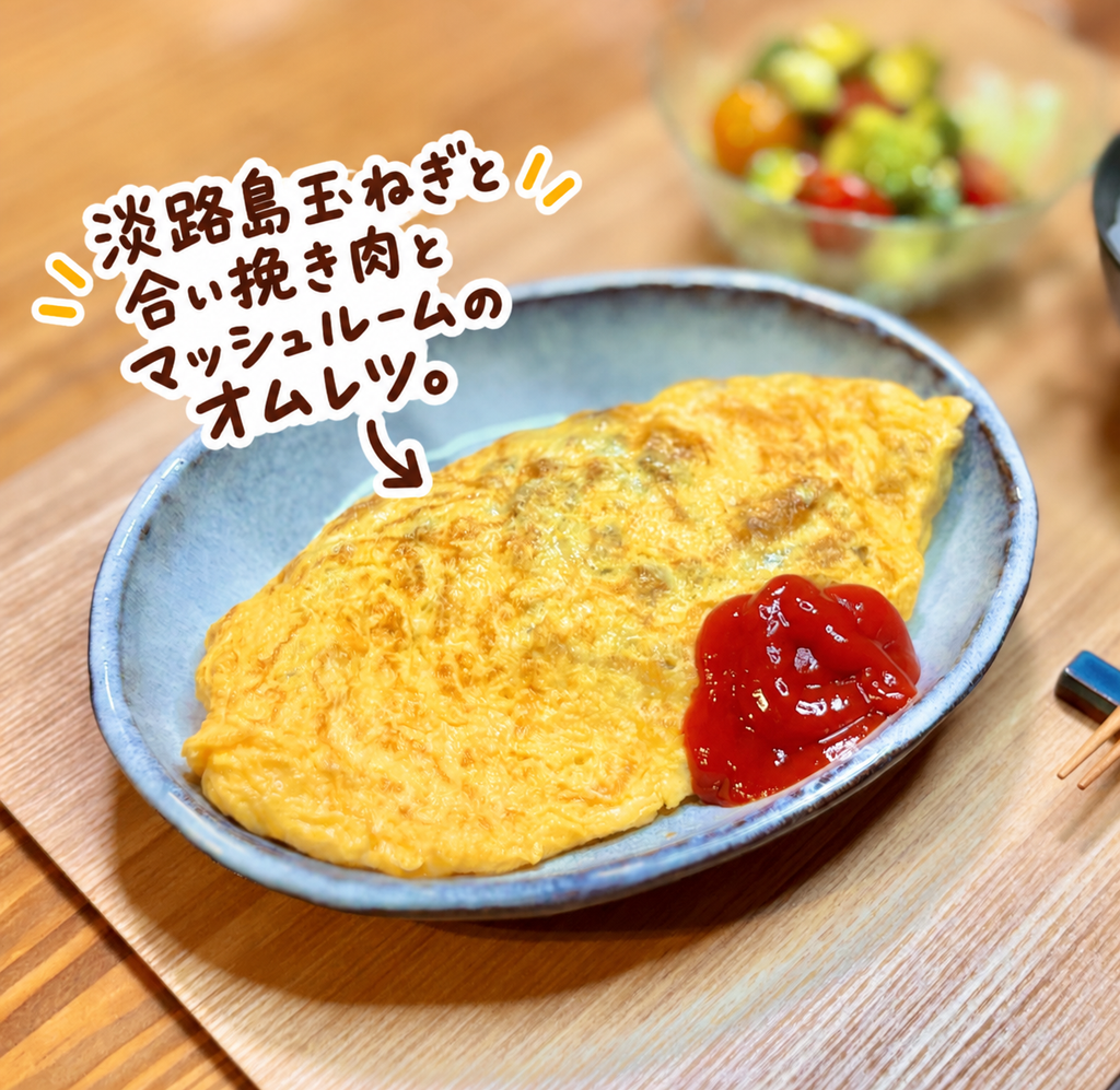 淡路島玉ねぎと合い挽き肉、マッシュルームを包んだ具だくさんオムレツにケチャップを添えた一皿